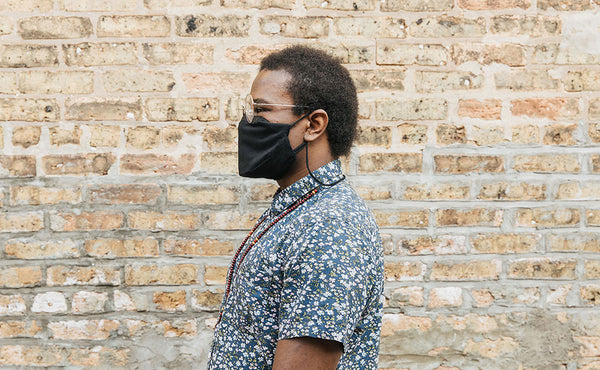 Person wearing the V4 Mask in 100% Cotton Flannel; background is a brick wall.